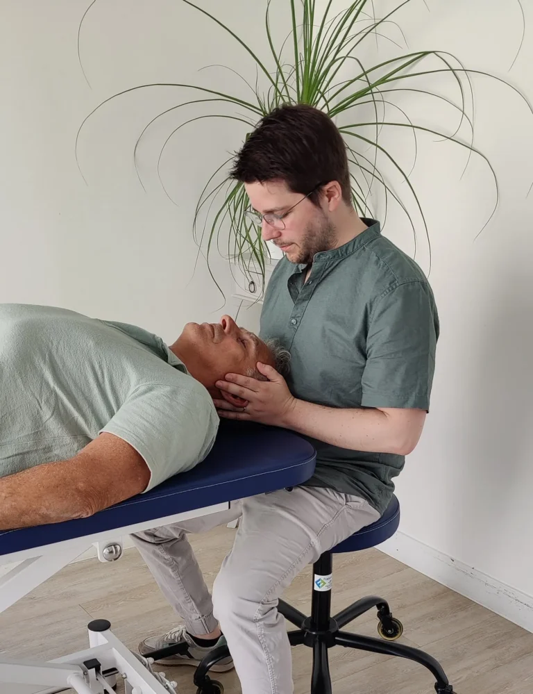 Adrien Mauviel-Lennard, ostéopathe à Colombes, en séance, technique sur la nuque et la mâchoire d'un patient